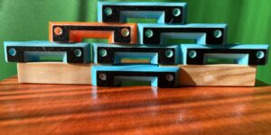 Das Bild zeigt die Anti Vespa velutina Flugloch Einengung. Oben als Bauteil, unten als Fluglochkeil für Mini Plus montiert,